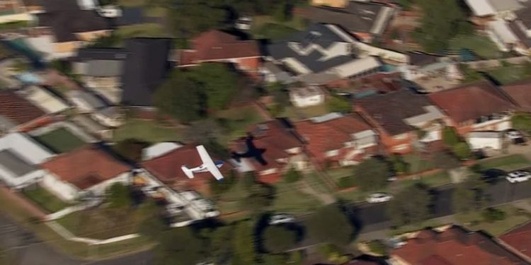 Small plane loses power and skims suburban rooftops before making crash landing on belly
